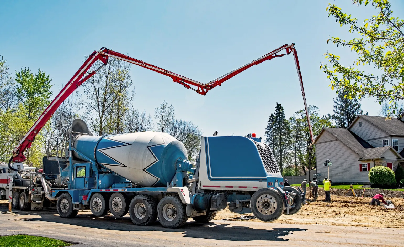 Concrete pump truck delivering fresh concrete to residential construction site