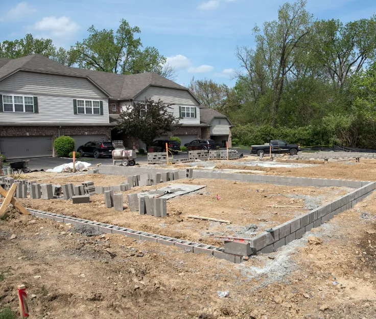 Fresh concrete being pumped into foundation forms on residential job site